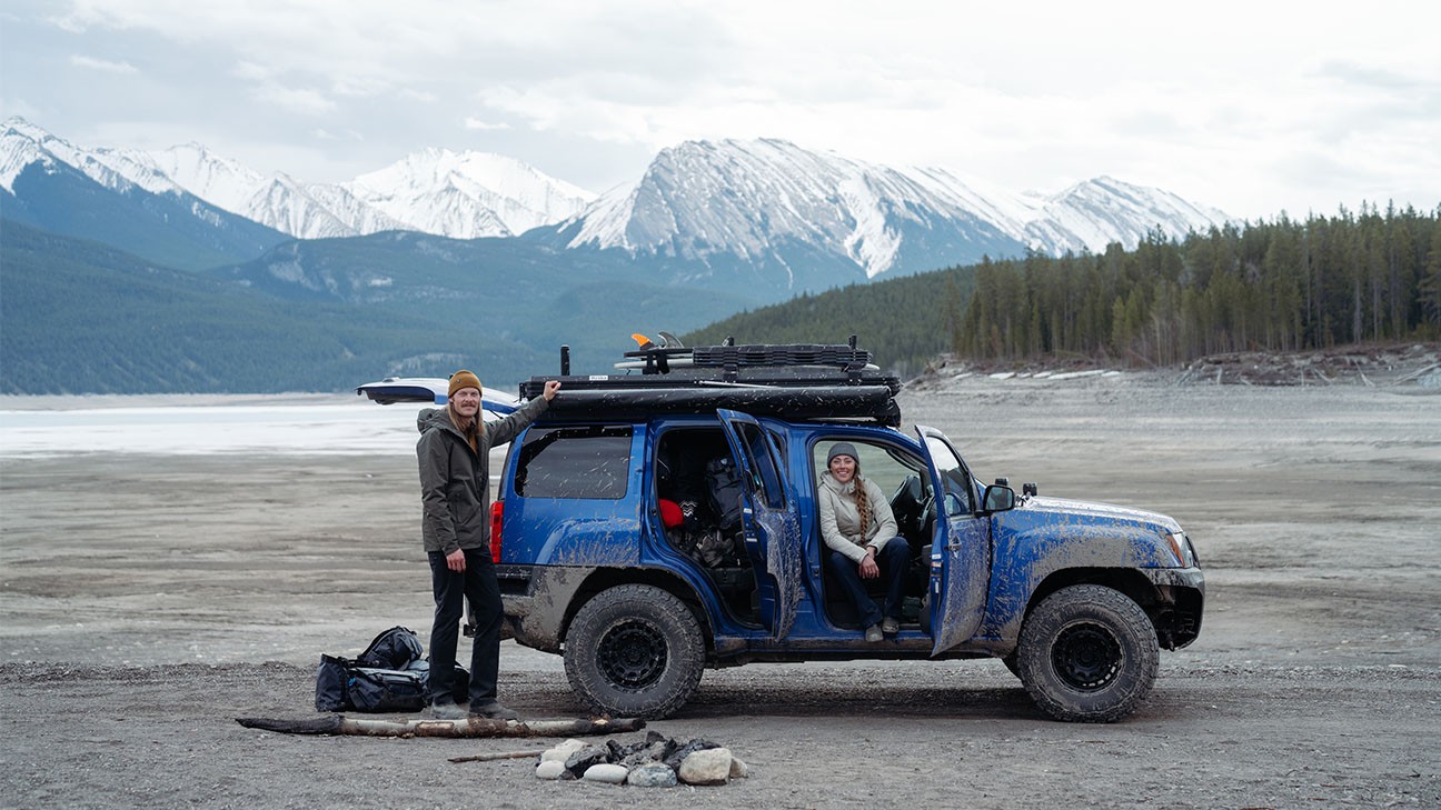 Claudio and Carlin in their four mud-stained four wheeler out in the backcountry
