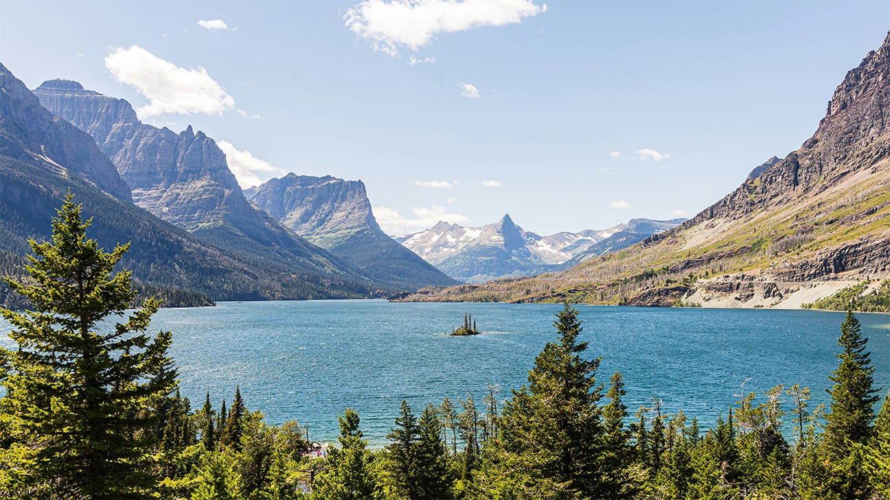 A large body of water surrounded by mountains - Glacier National Park