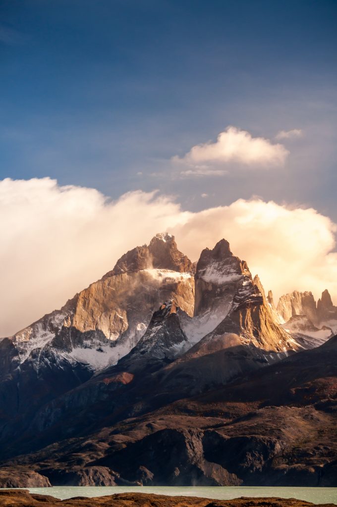Blue lake on a snowy mountains background and cloudy sky Torres del paine