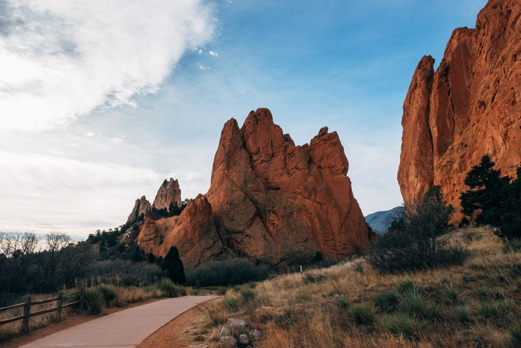 concrete road in the middle of two rock formations during daytime
