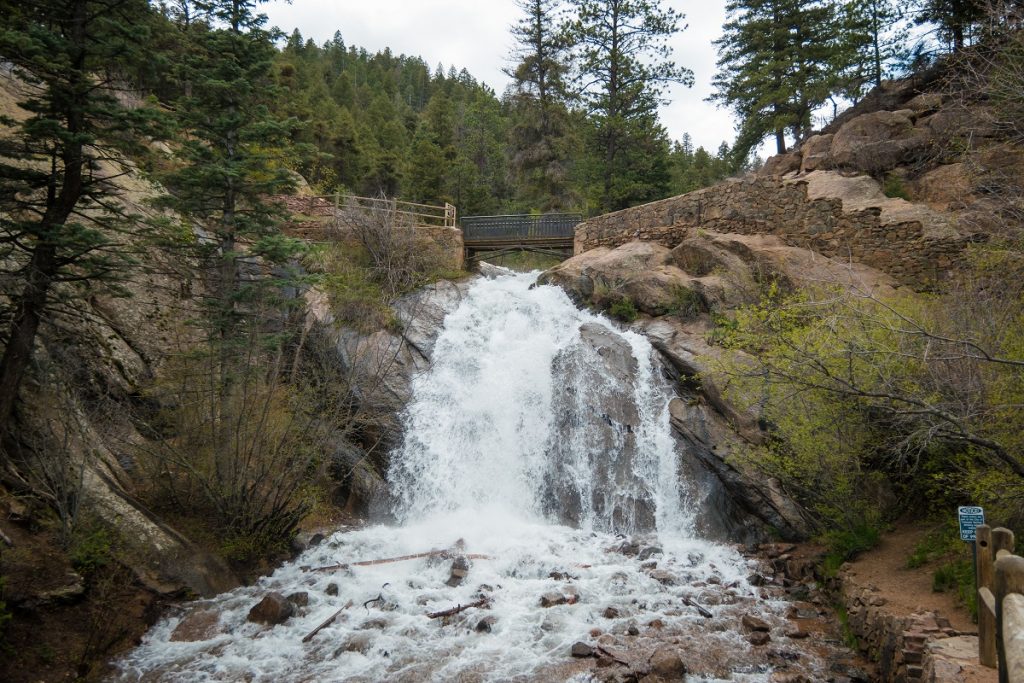 bridge on top of water falling on gray rocks