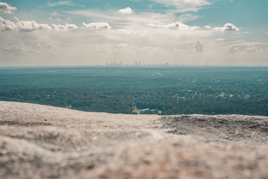 gray rock surface with buildings and sky in distance