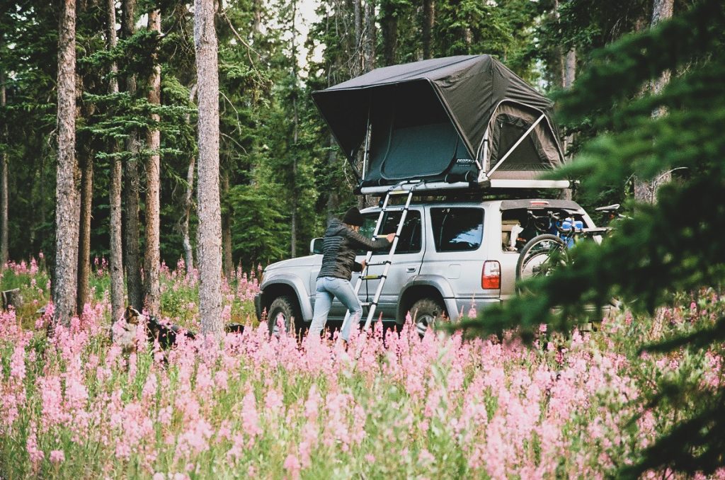 woman in K&Uuml;HL Spyfire Hoody climbing in car roof tent in the outdoors