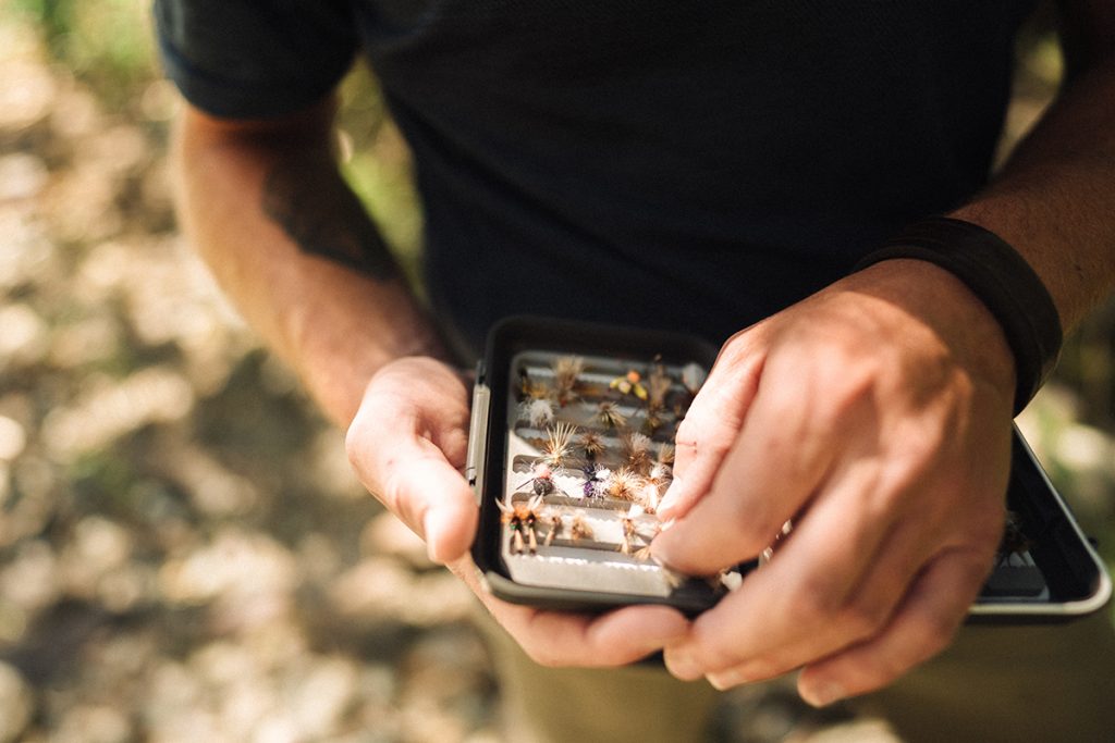 man in K&Uuml;HL Engineered Krew holding fly fishing lures